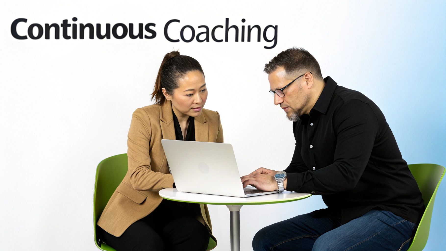 A sales manager coaching a team member in a collaborative office setting.