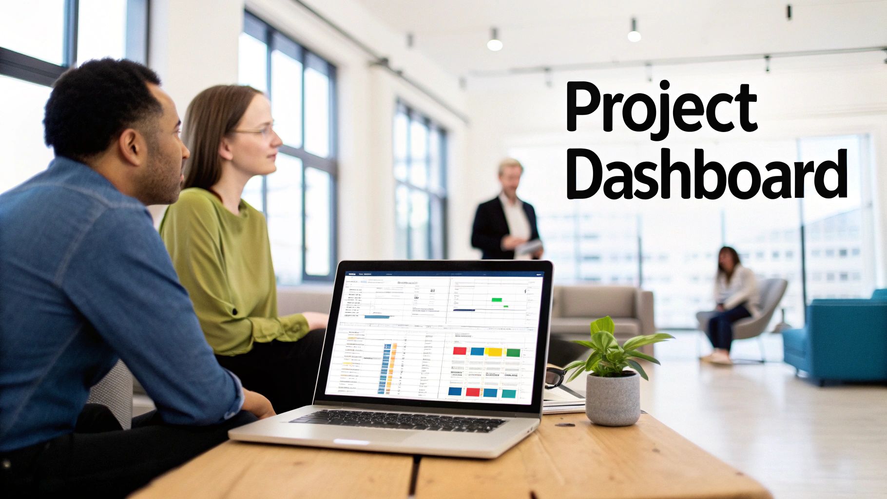 Two colleagues collaborate, looking at a laptop screen displaying a project dashboard in an office.