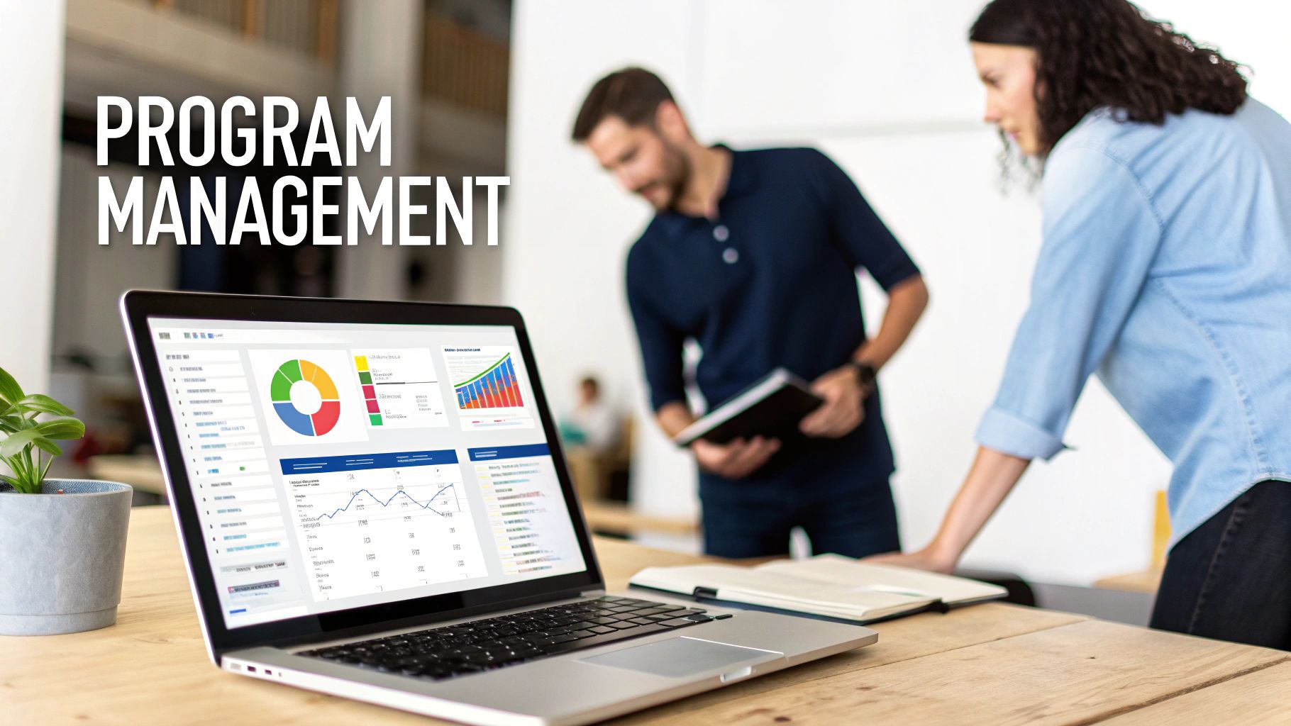 A laptop screen displays program management dashboards with charts, graphs, and data, with two people collaborating in the background.
