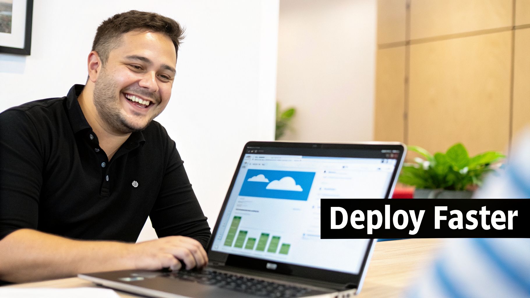 Smiling man working on a laptop in an office, screen shows cloud icons and 'Deploy Faster' text.