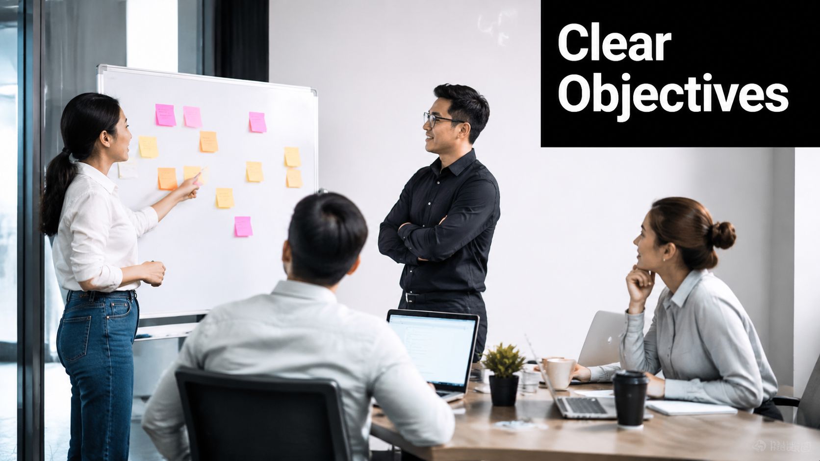 A professional team collaborating in a modern office with sticky notes on a whiteboard during a meeting.